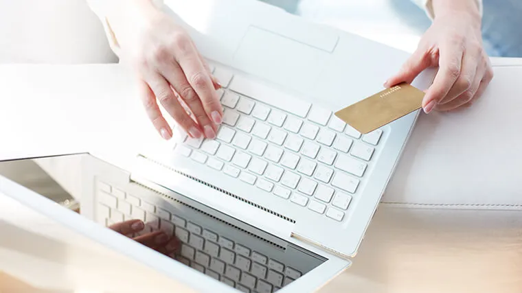Kobieta wykonująca transakcję online przy użyciu karty kredytowej
